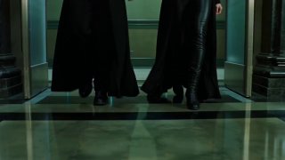 Кадр снизу: шаги людей в длинных плащах по блестящему полу коридора, акцент на композицию и отражения в кадре.