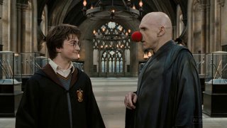 Кадр в интерьере большой залы: молодой персонаж в школьной форме и бледный антагонист с красным носом, сцена диалога и экспрессии лиц.