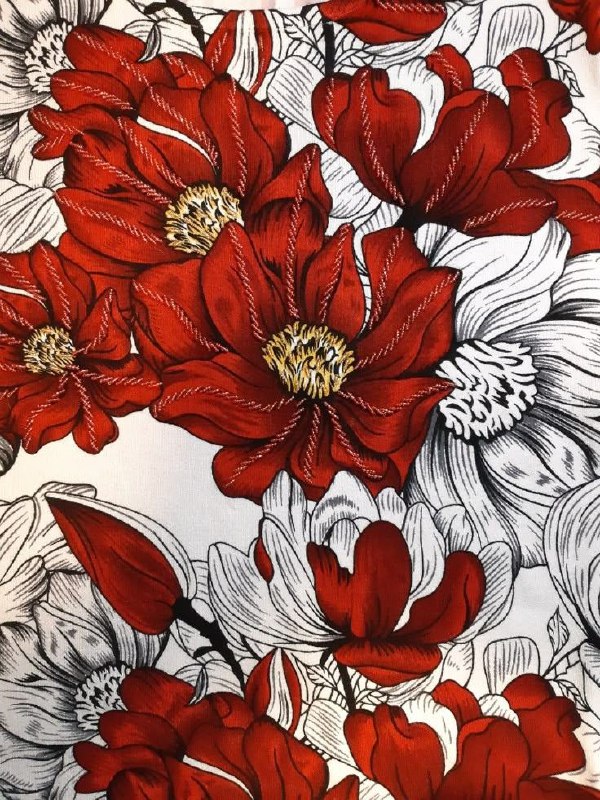 Крупный план принта с красными цветами на белом фоне — пример мотивов и принтов, где красный проявляет женственность и динамику в ткани.