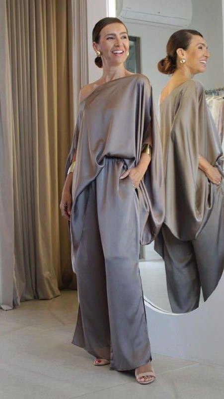 Две женщины в свободных однотонных сатиновых костюмах в серо‑бежевых тонах; струящиеся ткани и минимализм для элегантного спокойного образа.