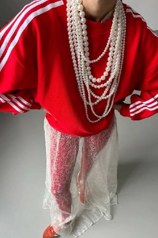 Стильный кадр: свитшот в спортивном стиле с несколькими длинными нитями жемчуга поверх, сочетание спорта и изящества.