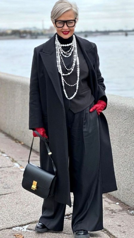 Городской образ: женщина в строгом пальто тёмного цвета, многослойные жемчужные нити добавляют мягкость и индивидуальность.