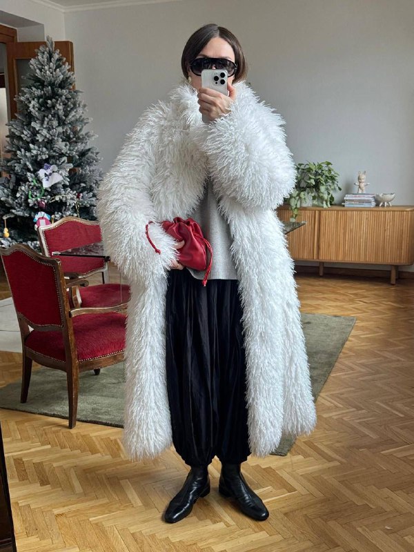 Комнатный кадр с длинной пушистой шубой и контрастной сумкой: мягкая текстура и объём, пример выбора для чувства защищённости.