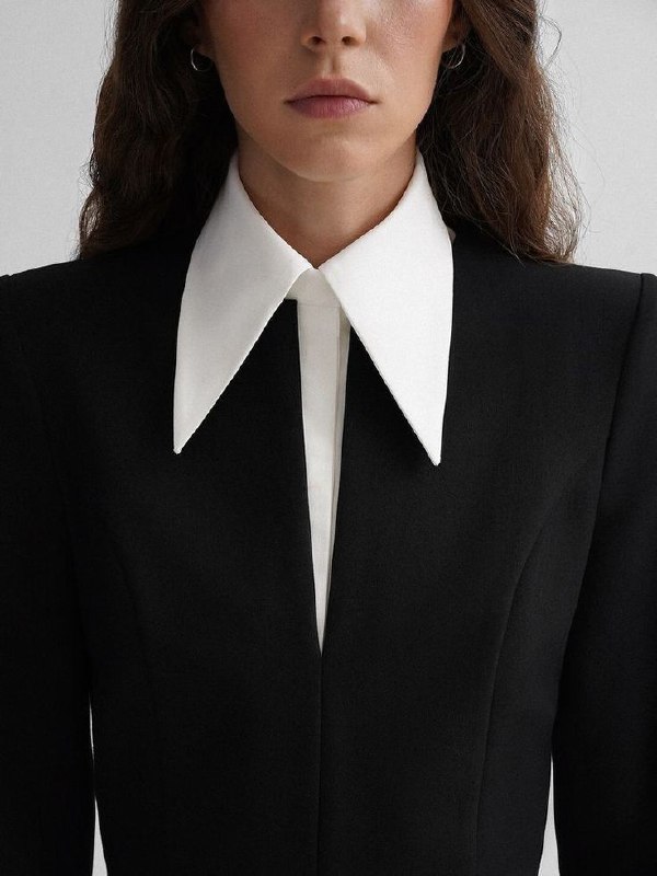 Женский образ в чёрном жакете с крупным белым воротником; строгая геометрия и рамка, передающая ощущение порядка, опоры и структурности в стиле.