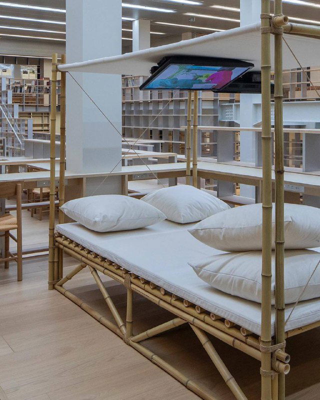 Уютная лаунж‑зона с соломенной мебелью и подушками внутри библиотеки — пространство для отдыха и просмотра программ в культурном центре.