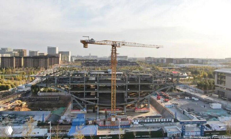 Строительная площадка центра «Крылья Сюнъаня»: многоуровневая железобетонная конструкция и кран в процессе возведения каркаса будущего пятиэтажного здания.