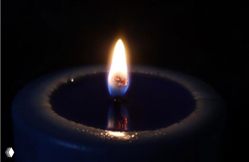 Крупный план ровного пламени свечи на тёмном фоне: мягкий свет и едва заметное движение, символ спокойствия и фокусировки внимания.