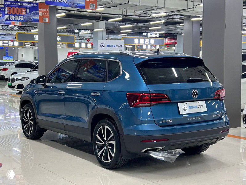 Задняя часть Volkswagen Tharu 1.4T 2WD в салоне: багажник, фонари и профиль кузова на демонстрационной площадке дилера.
