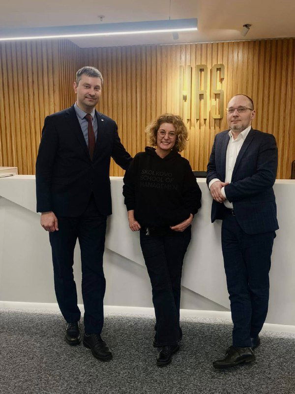 Трое людей в офисе HRS Russia у стойки ресепшн — деловое фото с визита HCB Consultancy во время презентации Sonata и обсуждения продукта.