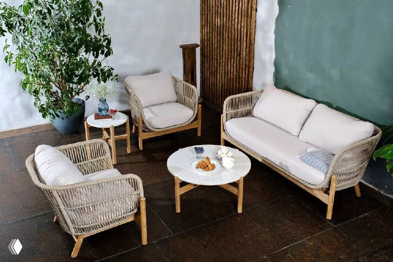 Гостиная зона с двумя креслами и диваном TALARA: пастельная палитра, плетёные боковины и деревянные элементы, уютная расстановка мебели.