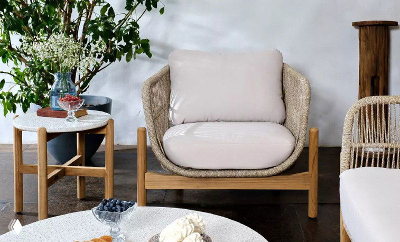 Удобное кресло из коллекции TALARA с округлой спинкой и мягкой подушкой, на фоне декора и небольшого столика — эстетика и комфорт.