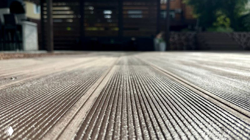 Макрофото фактуры террасной доски NewWood Classic: рельефная поверхность, видны протекторы и рисунок, демонстрирующий качество ДПК.