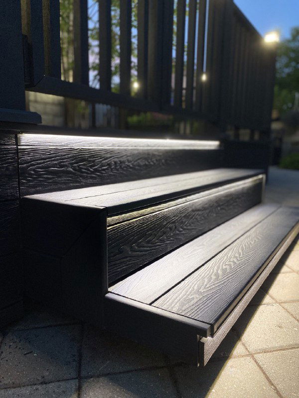 Крупный план ступеней и кромки доски из ДПК чёрного цвета, текстура древесного рисунка и ровная кромка для безопасного подъёма.