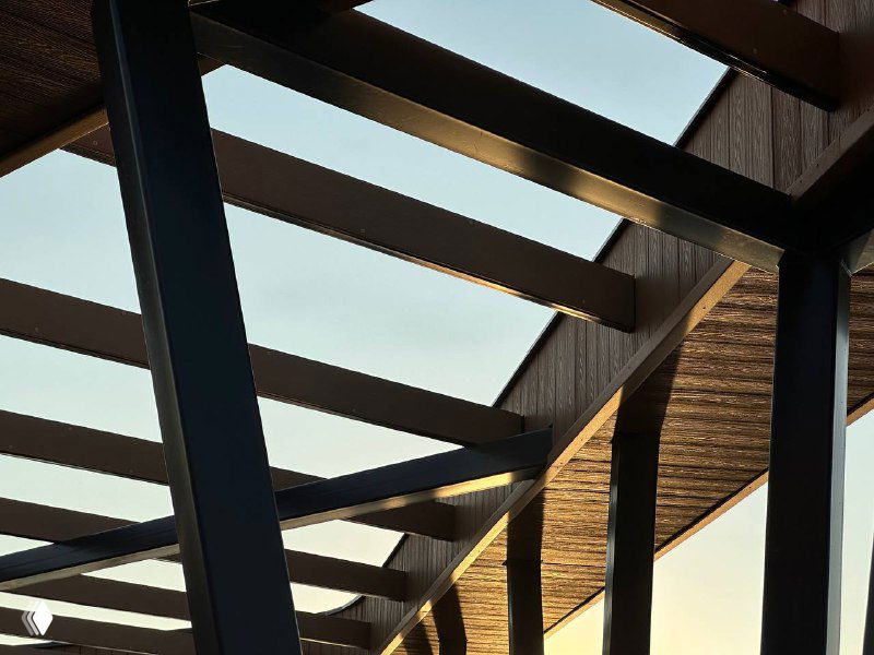 Стальная конструкция навеса с деревянными элементами ДПК сверху: сочетание металла и имитации дерева в архитектурной детали на береговой линии.