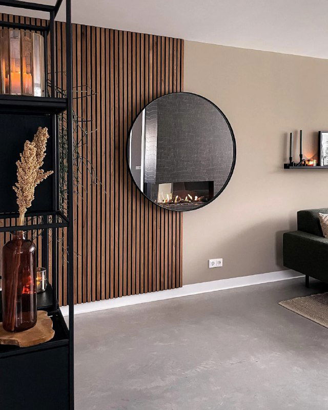 Уютный уголок с брусковыми панелями, круглое зеркало и мебель в современном стиле создают эффект глубины и текстурности стены.