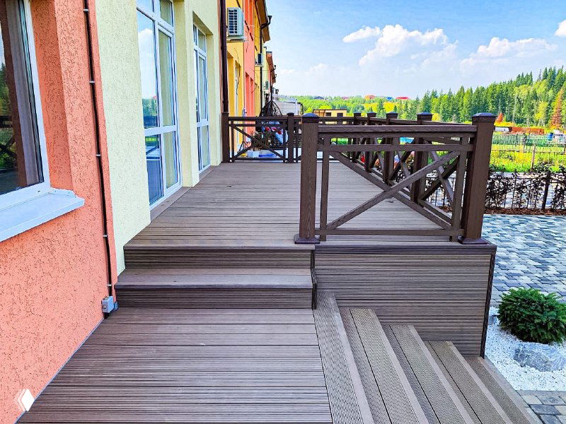 Крупный план ступеней и настила террасы из ДПК ProDecking: видна текстура досок, аккуратные стыки и оформление у входа в дом.