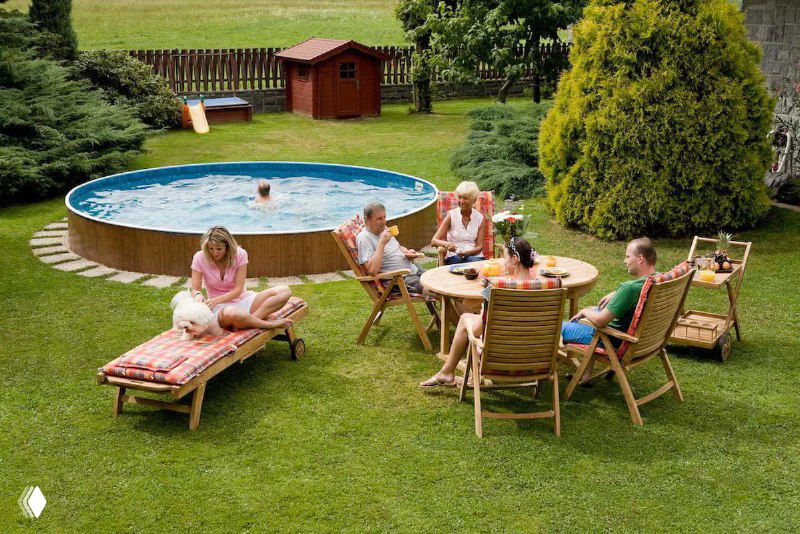 Летняя лаунж-зона с бассейном, шезлонгами и столиком на газоне — место для отдыха всей семьи и друзей в тёплое время года.