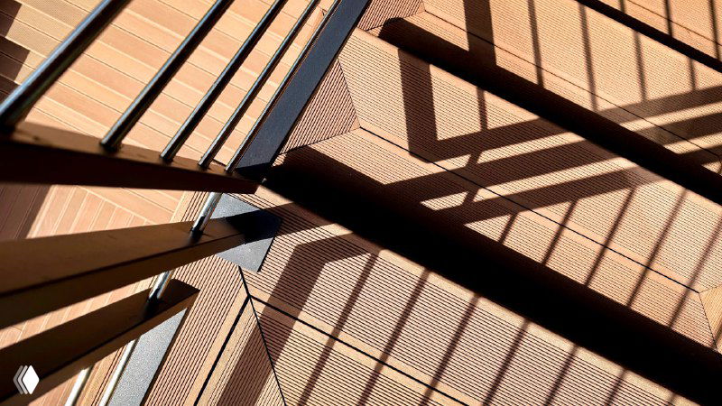 Тональные тени от ограждения падают на террасную доску, подчёркивая рифлёную структуру покрытия из ДПК Polivan.