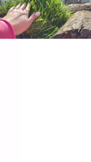 Кусок свежего рулонного газона крупным планом: видна зелёная травяная полоса и рука человека рядом, сцена разгрузки на участке.