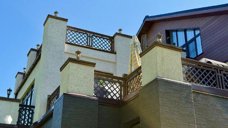 Вид балкона и ограждений второго этажа, отделанных древесно‑полимерным композитом, гармония с архитектурой дома и стойкость цветовой палитры на солнце