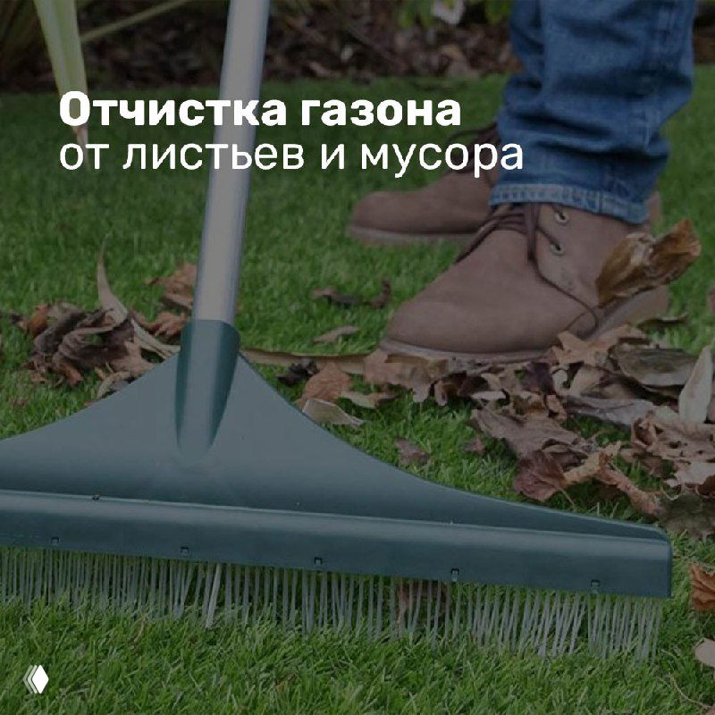 Ближний план граблей на траве и опавшие листья у ног человека — визуал подсказки по очистке газона от листьев и мусора.