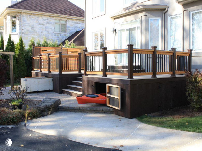 Терраса с ограждением и скрытыми нишами для хранения под настилом: ступени, ящики для вещей и декоративные балясины.