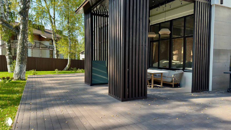 Угол террасы рядом с павильоном, настил Polivan SINGARAJA и часть садовой мебели TALARA на фоне зелёного участка