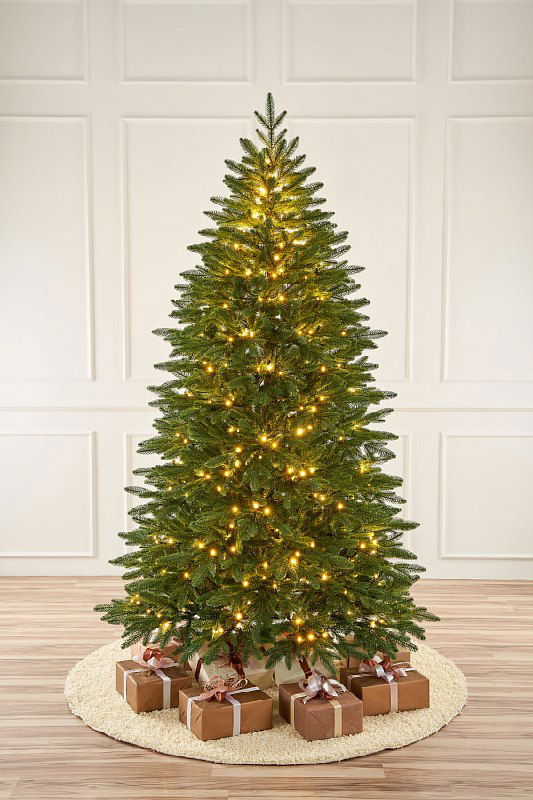 Фотография Самарской ёлочки в полный рост с включённой гирляндой, стройная форма и декоративные подарки у основания.