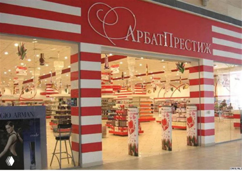 Вход в магазин сети «Арбат Престиж»: красно-белая вывеска и просторный торговый зал с промо-стендом у входа и рядами товаров.