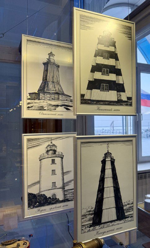 Серия рисунков и схем маяков в витрине: графические изображения различных маяков с подписями, часть выставки по навигации и береговой архитектуре.