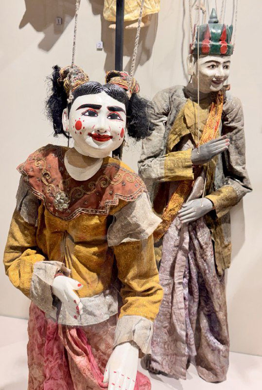 Пара кукольных фигур с выразительными лицами и тканевыми костюмами — пример карнавальной и масочной традиции в экспозиции.