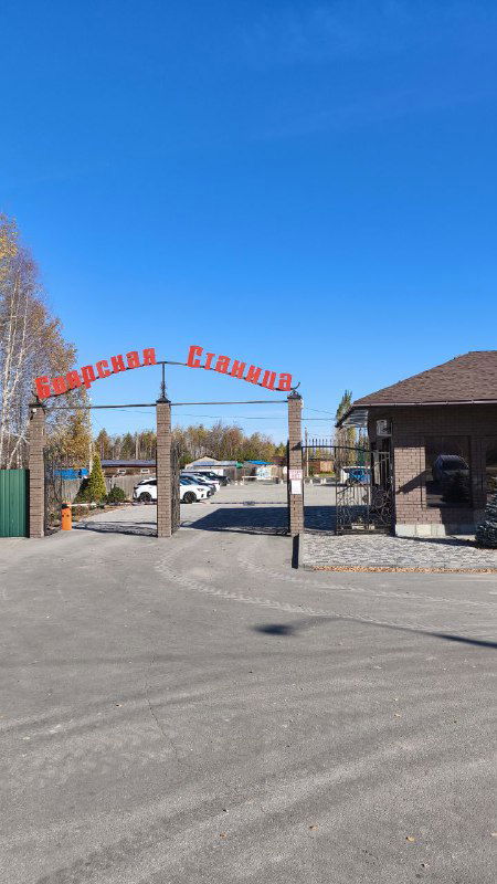 Въездная арка с надписью «Боярская Станица» у входа на территорию отдыха, асфальтовая дорога и парковка в ясную погоду.