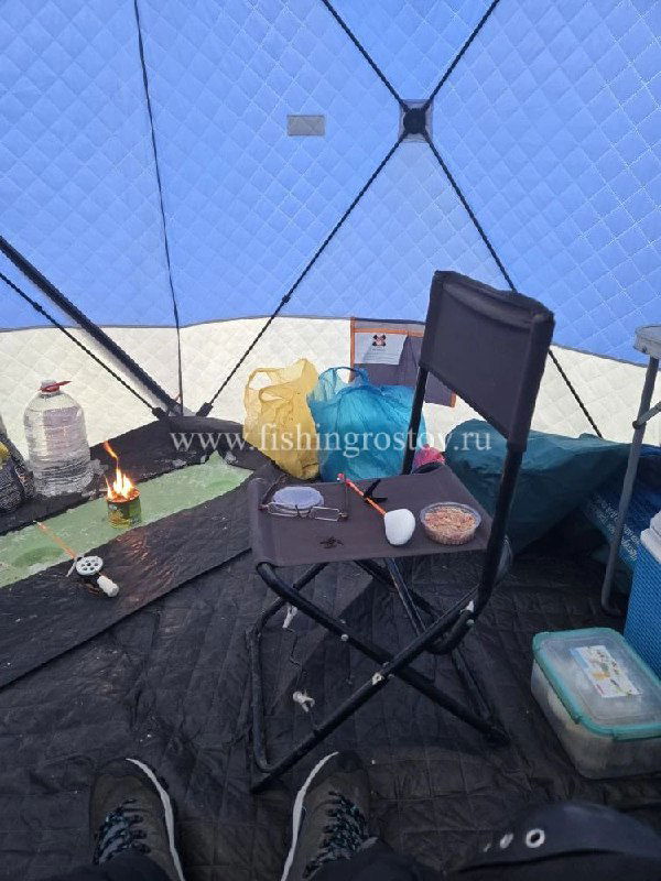Стул и коробки с прикормкой внутри палатки, на столе банки и снасти — типовая обстановка при зимней ловле таранки на Маныче.