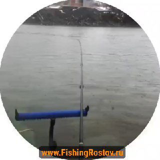 Вид с точки ловли: удочка, направленная на реку, мокрая гладь воды и дальний берег в пасмурную погоду, круговой кадр.