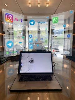 Ноутбук в кафе; вокруг виртуальные иконки Telegram, Instagram, WhatsApp и CRM — иллюстрация внедрения ИИ в бизнесе