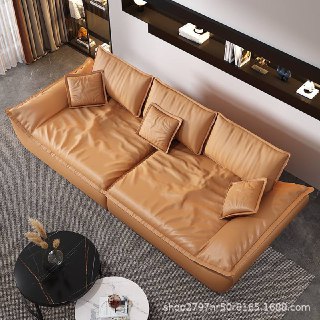 Вид сверху на коричневый кожаный диван Галеон, заметна текстура кожи, посадочные места и декоративные подушки в нейтральной гостиной.