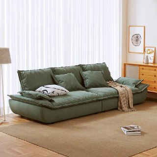 Зеленовато-серый диван Галеон с подушками и легким пледом, показан в уютном интерьере с естественным освещением и мягким ковром.