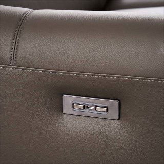 Детальное фото панели управления электромотора дивана Cowhide: кнопки реклайнера из металла на боковой части подлокотника.
