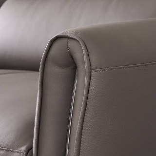 Крупный план кожаного подлокотника дивана Cowhide, показывающий строчку швов и текстуру воловьей кожи.