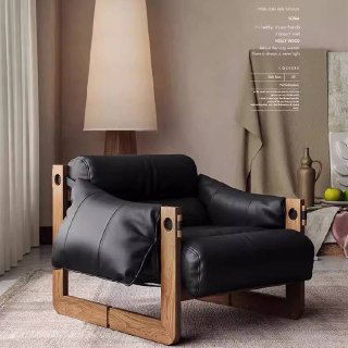 Чёрное кресло из искусственной кожи с массивной деревянной рамой, акцент на контрасте кожи и дерева в комнате.