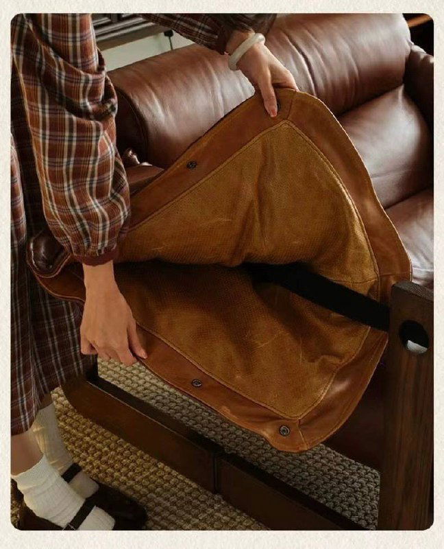 Фото человека, снимающего кожаную накидку с каркаса кресла, показана конструкция и возможность съёмной обивки крупным планом.