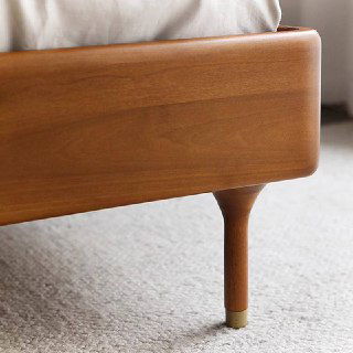 Деталь ножки кровати Madrid: тонкая шлифованная ножка из массива ясеня с металлической накладкой на конце и гладкой обработкой.