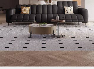 Тёмно-серый модульный диван с ровной линией спинки и низкими ножками, показан в минималистичном интерьере с ковром и журнальным столиком