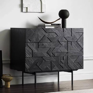 Вид сбоку на чёрный деревянный комод из массива ясеня с акцентным геометрическим рисунком на фасаде и высокими ногами.