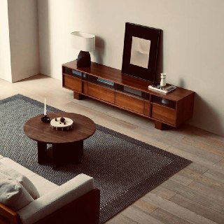 Угловой вид комнаты с ТВ-тумбой из ясеня: тумба, ковер и кофейный столик, показан общий масштаб и сочетание материалов в интерьере.