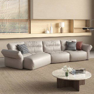 Угловая модель дивана светло-серого тона в минималистичной комнате, крупный план секций сидений и фактуры обивки на фоне деревянных полок.