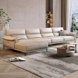 Угловой бежевый диван с приставным шезлонгом у большого окна; видно ковёр и журнальный столик, вид под углом на модель.