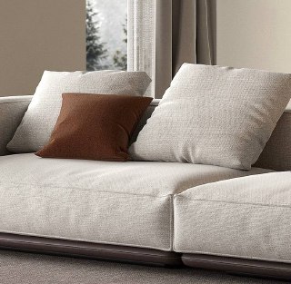 Макро-снимок посадочной поверхности и подушек дивана, демонстрирующий швы, наполнение и структуру обивки из хлопка и льна в нейтральной палитре.