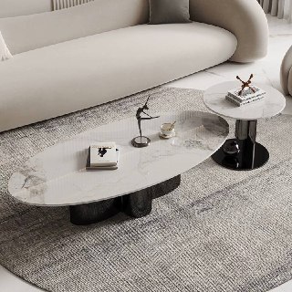 Круглый и овальный журнальные столики с мраморными столешницами и глянцевыми черными основаниями на ковре возле дивана.