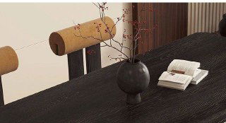 Крупный план столешницы из тёмного массива ясеня: текстура древесины, декоративная ваза и открытая книга на поверхности столешницы.